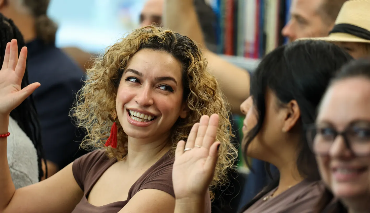 A participant smiles and waves at a Meridian Transformative Learning Lab