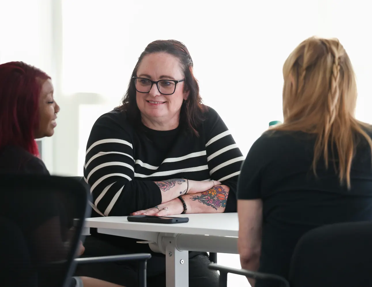 Three participants in conversation around a table at a Meridian Transformative Learning Lab